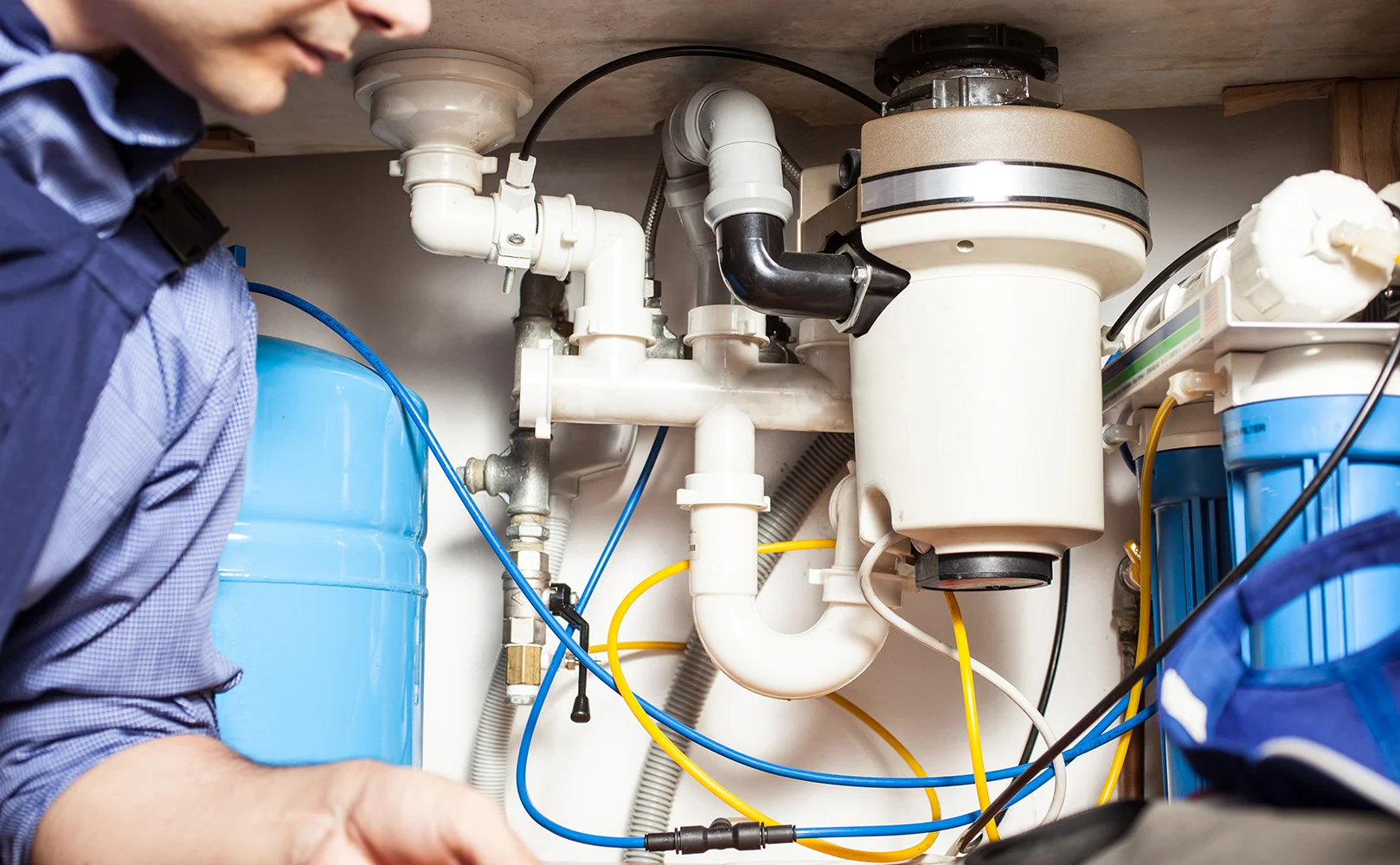 plumber installing reverse osmosis system under sink