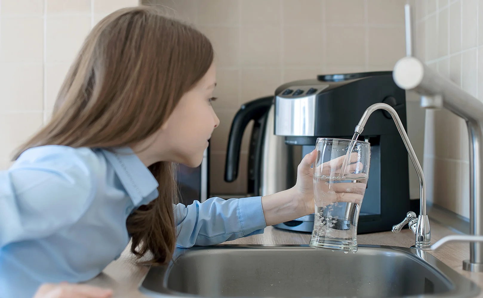 young girl opening reverse osmosis faucet