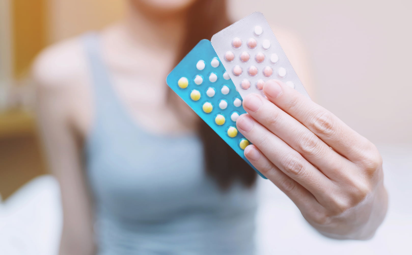 woman holding birth control pills in hand